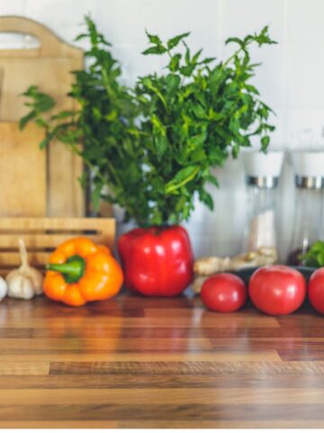 Wooden chopping board with peppers, tomatoes and garlic