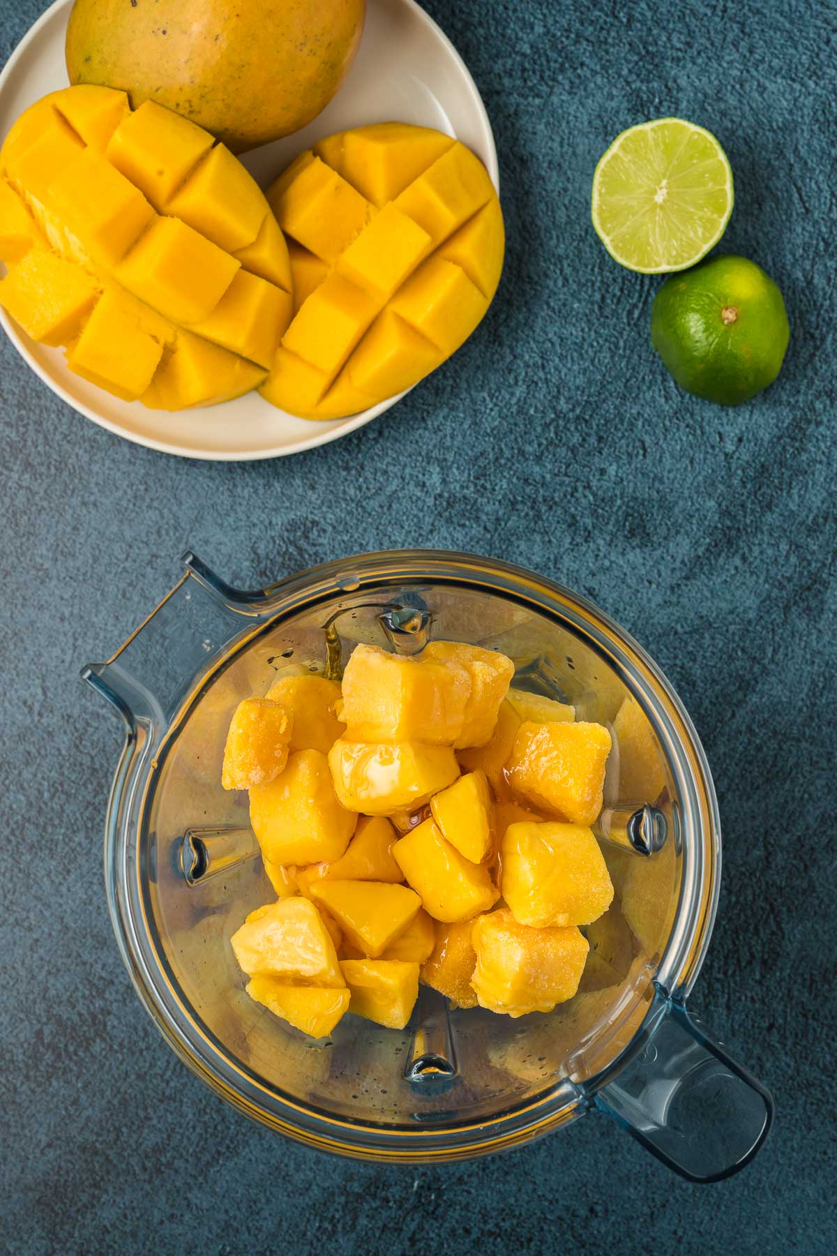 Mango chunks in blender on dark background