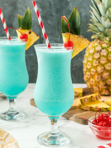 Two blue hawaiians with pineapple and cherries