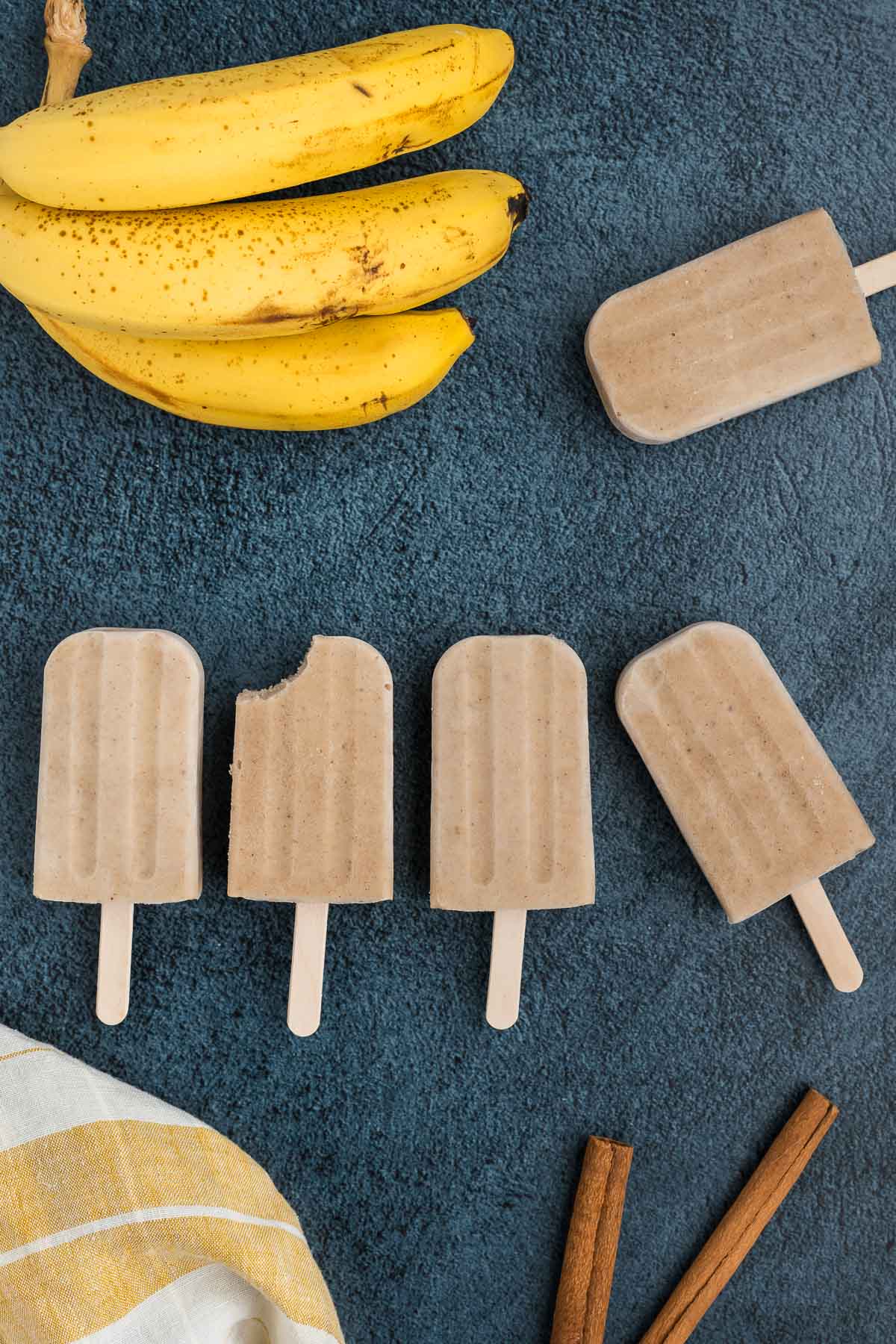5 banana popsicles with bananas on dark background